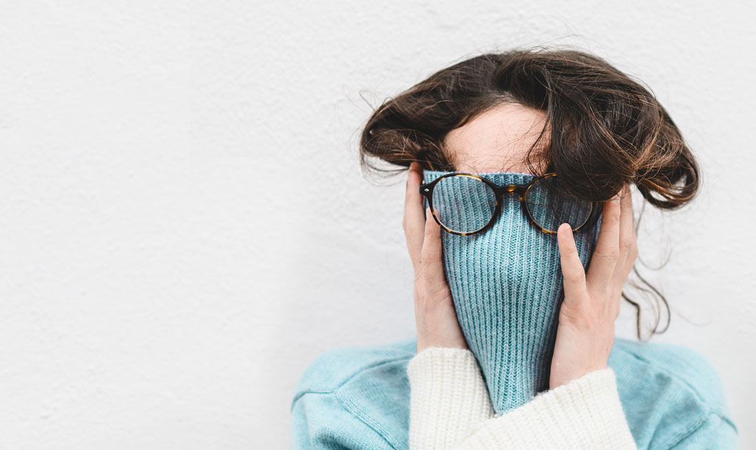 Woman covering her face with her sweater